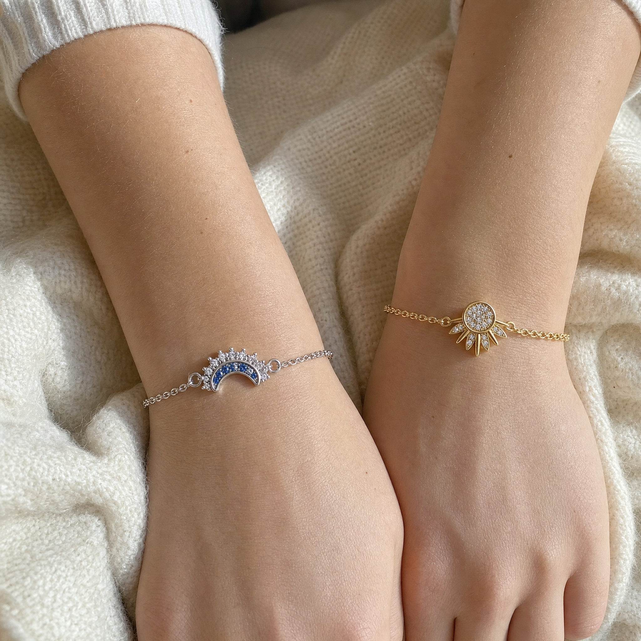 Two wrists wearing the pair, silver moon and gold sun