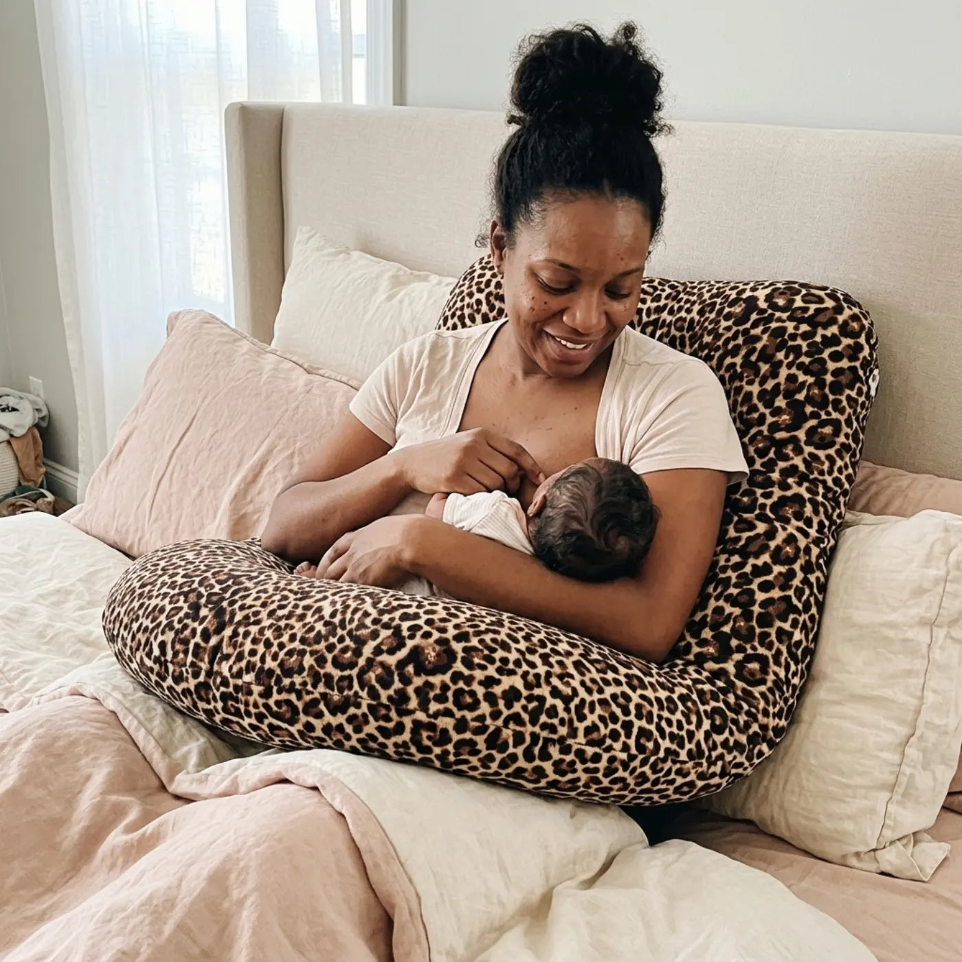 Mother feeding her baby with the J-Pillow supporting her arm and back